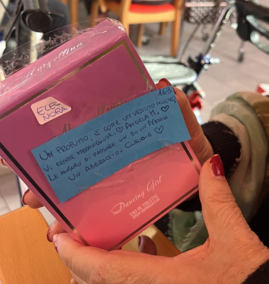 Una confezione di profumo con un biglietto scritto a mano da Claudia