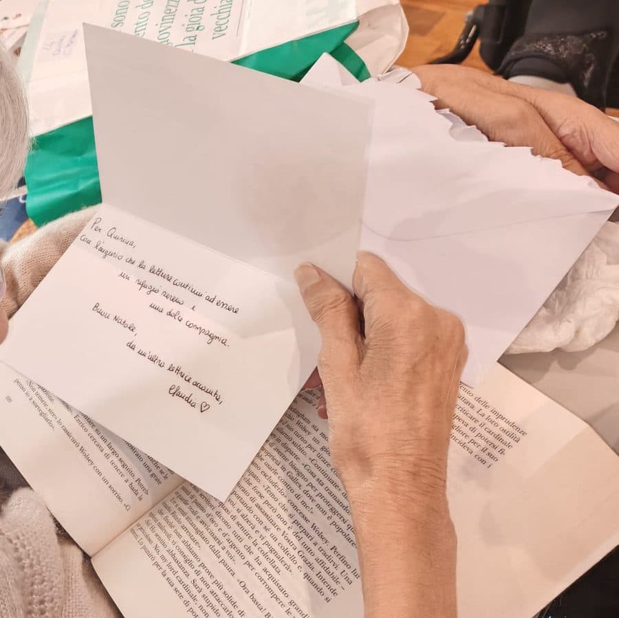 Un'ospite legge la lettera ricevuta insieme al regalo