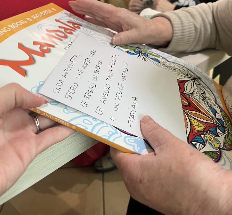 Un libro da colorare con il biglietto di Tatiana, tra le mani di un'ospite